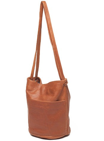 an erin templeton leather handbag with a bucket shaped body, a large off-centre pocket and dual crossbody straps. shown in caramel leather