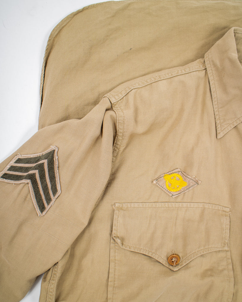 closeup of patches on khaki 1940's air force button down with two pockets on the chest