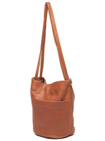 an erin templeton leather handbag with a bucket shaped body, a large off-centre pocket and dual crossbody straps. shown in caramel leather