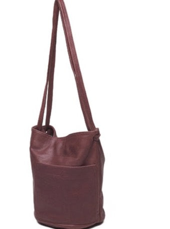 an erin templeton leather handbag with a bucket shaped body, a large off-centre pocket and dual crossbody straps. shown in wine leather