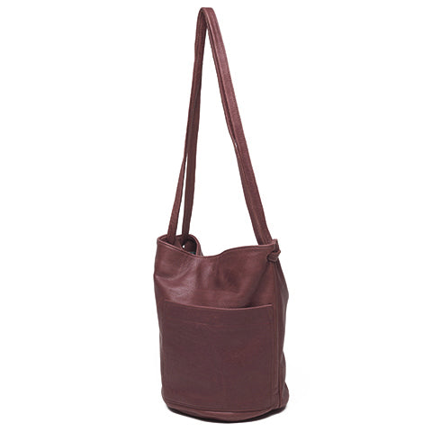 an erin templeton leather handbag with a bucket shaped body, a large off-centre pocket and dual crossbody straps. shown in wine leather