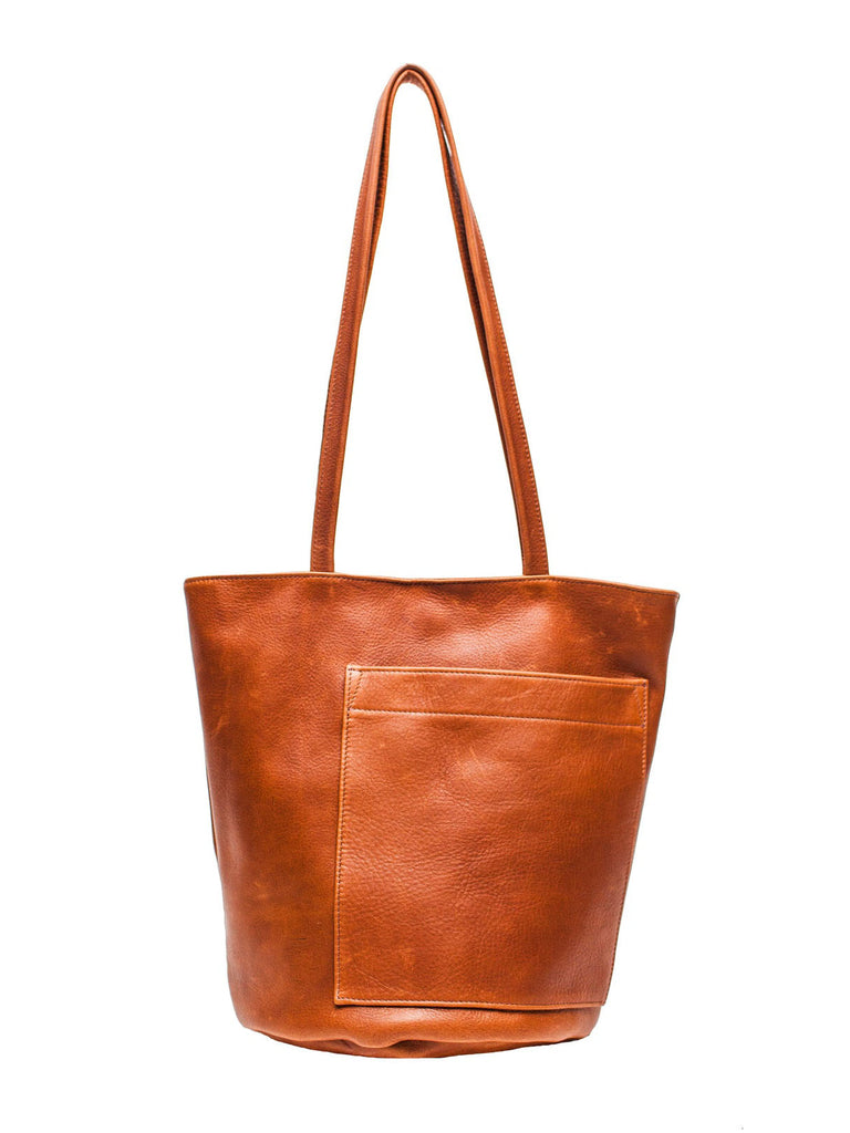 erin templeton bucket bag in caramel leather, propped hanging with handle up against white background.