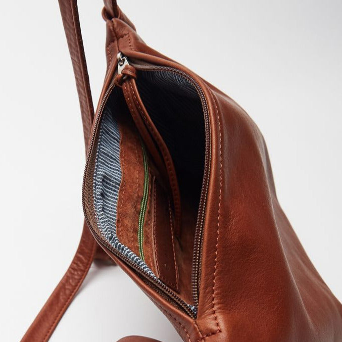 the interior of a small caramel leather purse with zip closure, a hickory stripe lining and an inner leather zip pocket, handmade by erin templeton in vancouver, canada
