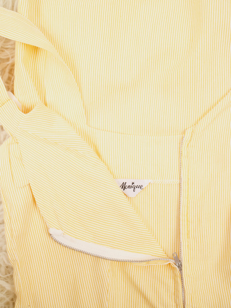 closeup of label of a 1940's / 1950's MONIQUE lemon striped romper with a zip down the front and two pockets