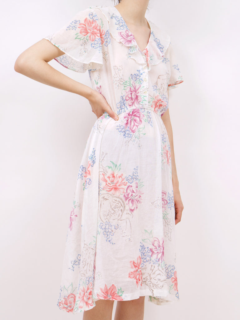 the side of a blouson style dress with a floral pattern and ruffle details