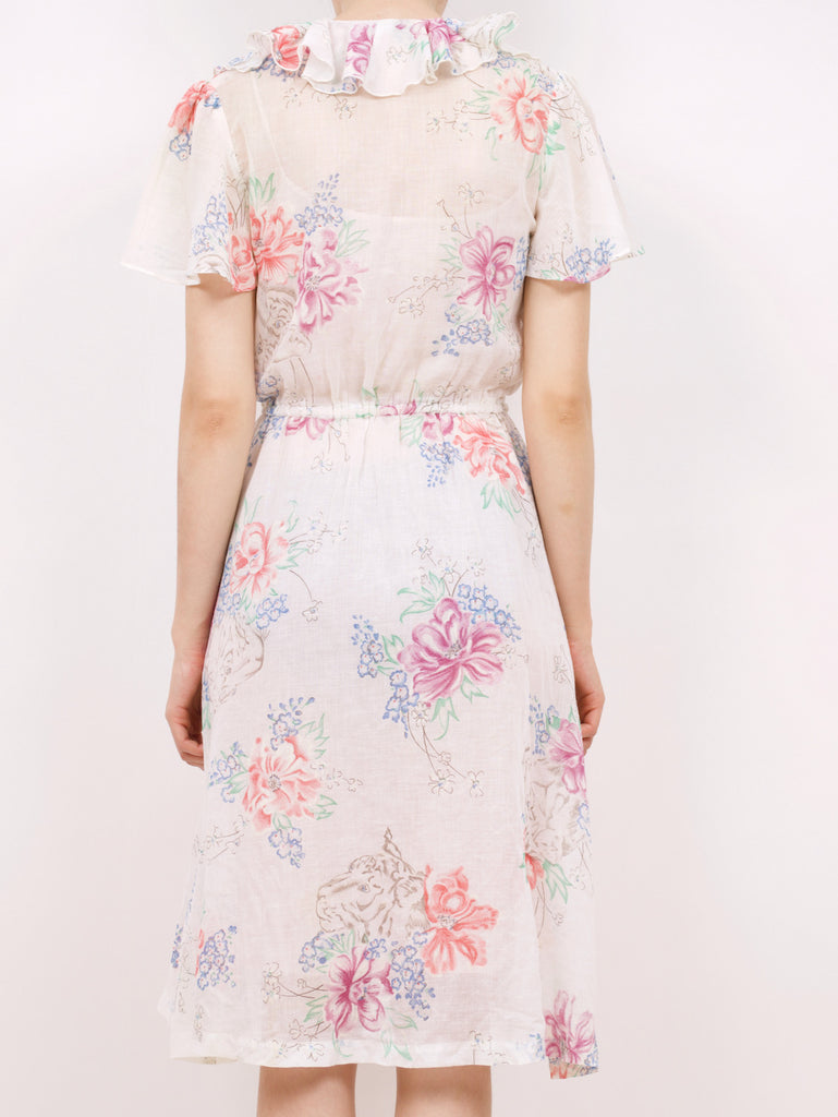 the back of a blouson style dress with a floral pattern and ruffle details