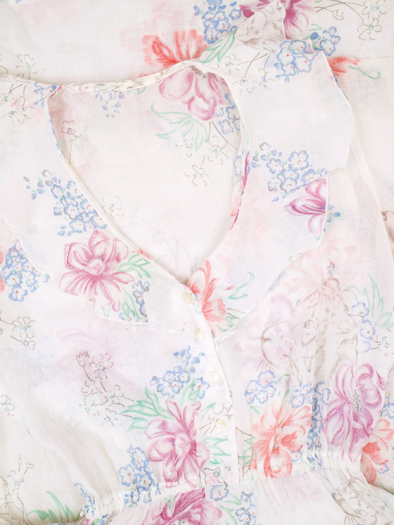 the neckline of a blouson style dress with a floral pattern and ruffle details